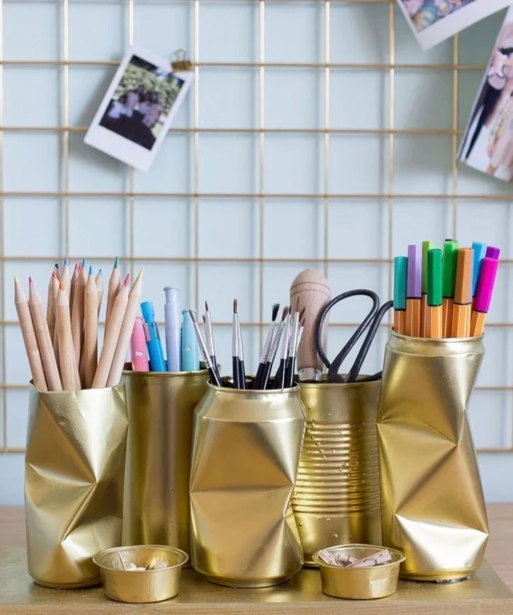 DIY stojany na ceruzky zrekultovaných plechoviek zdobia stôl v kreatívnej zóne.