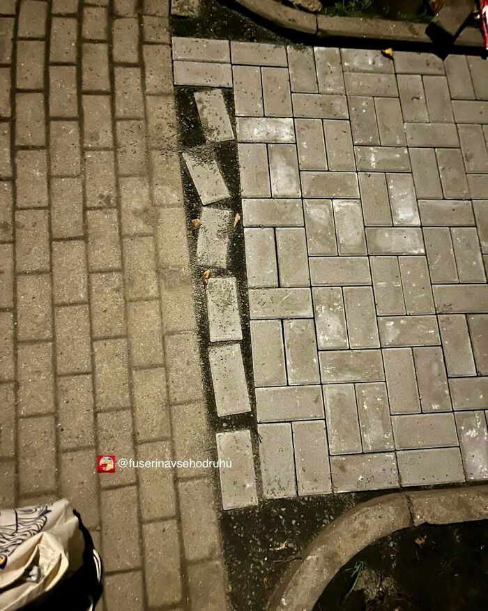 Nepresne zarovnané dlažobné kocky na chodníku vedľa správne položenej časti.