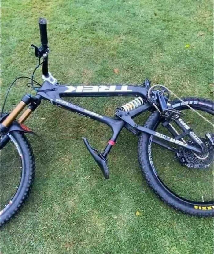 Horský bicykel s odpružením položený na tráve, pripravený na jazdu v teréne.