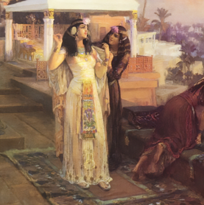 Dve ženy v staroegyptskom oblečení pri príprave na udalosť na terase s palmami a architektúrou v pozadí.