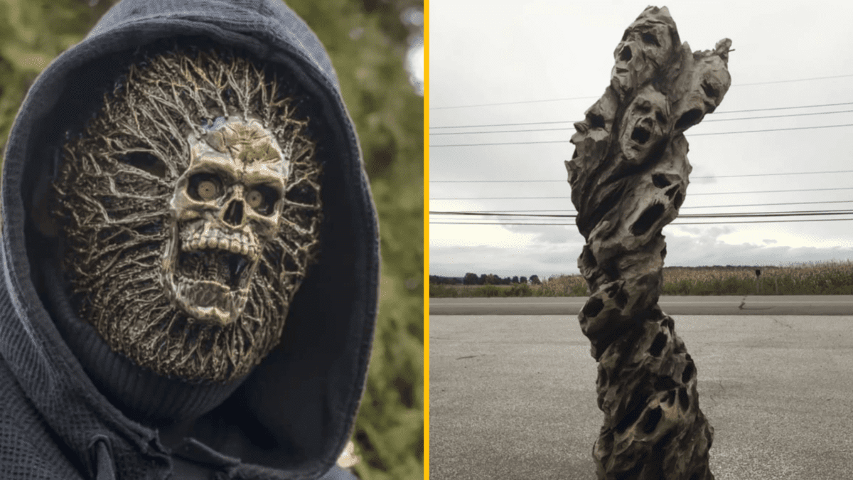 Strašidelná maska a socha s vyrezávanými lebkami vytvárajú desivú atmosféru na strašidelnej výstave.