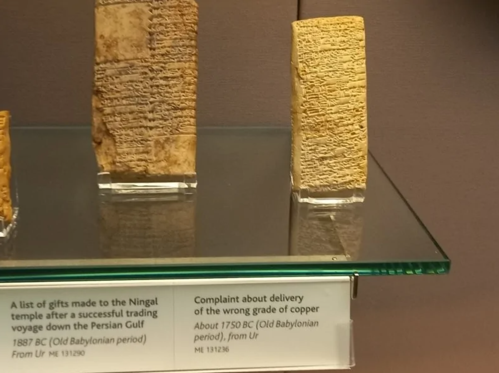 Starodávne babylonské tabulky s klinovým písmom, opisujúce dary a reklamáciu medi, múzejná expozícia.