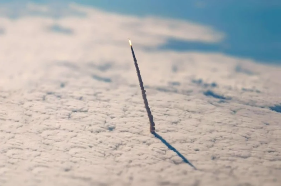 Raketa vystreľujúca cez oblaky, zdôrazňujúca technologické pokroky v oblasti vesmírnych letov.