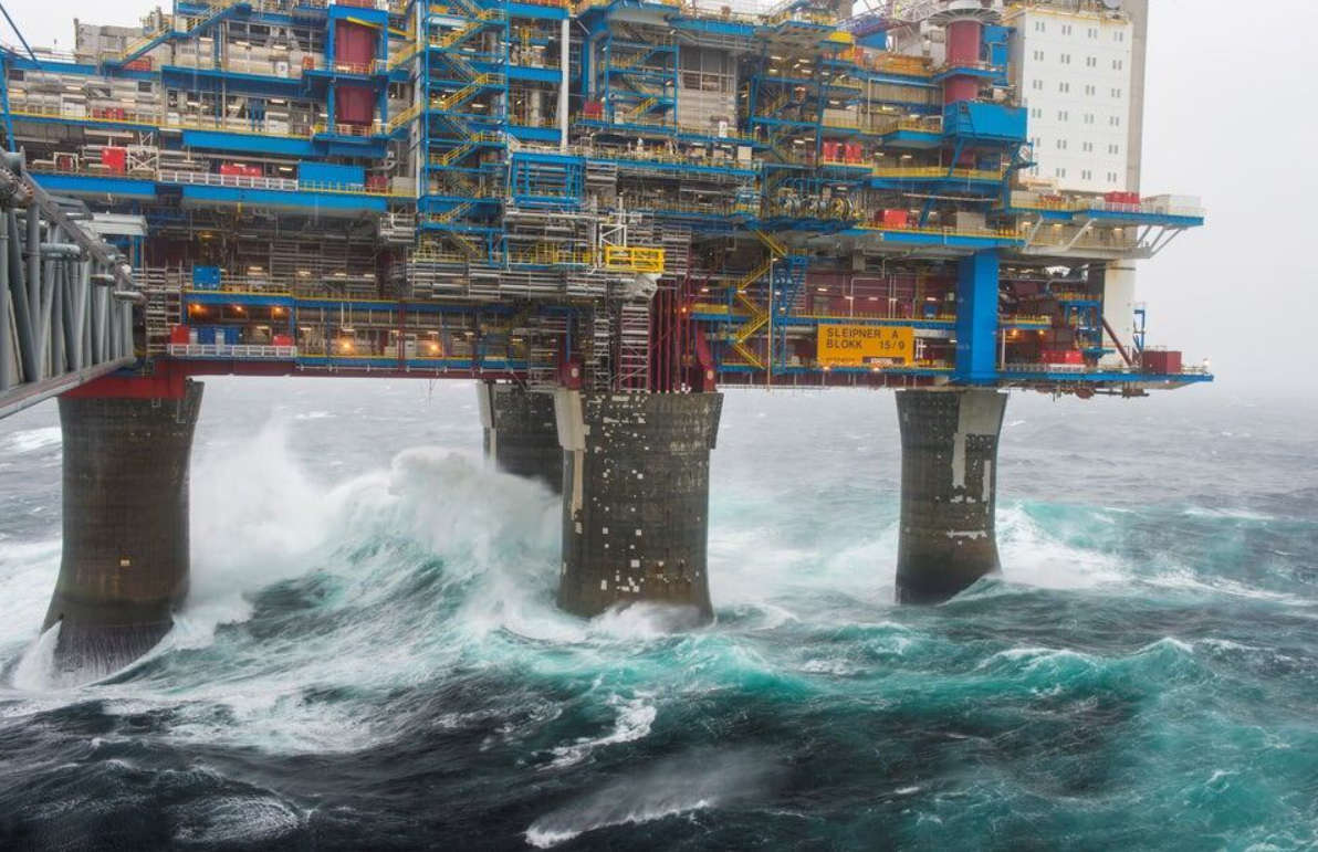 Ropná plošina nad búrkovým oceánom, vlny narážajú na konštrukciu, dramatické počasie, priemyselný komplex na mori.