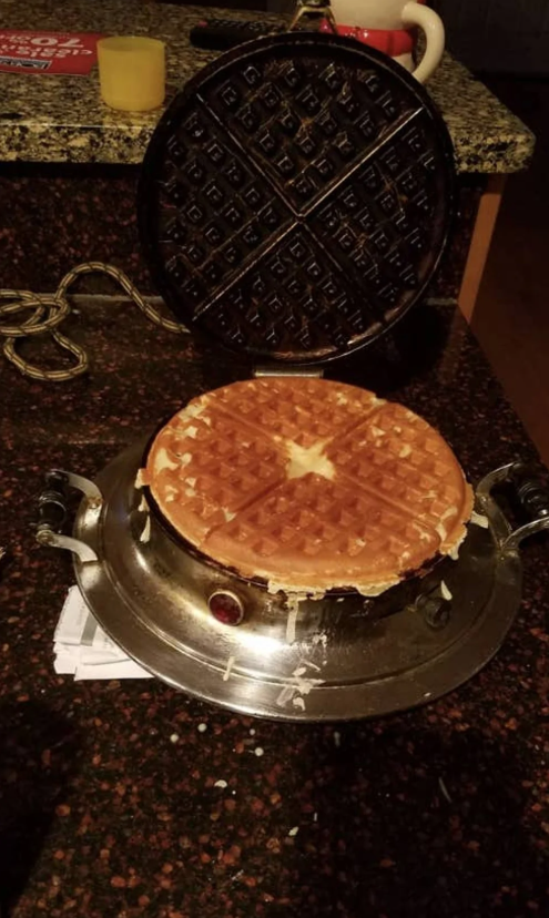 Čerstvo upečená vafla na kuchynskej linke vedľa vaflovača, pripravená na servírovanie.