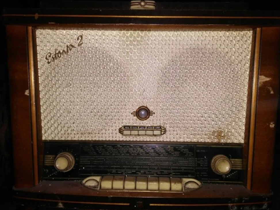 Staré retro rádio s dreveným rámom a ovládacími prvkami, naznačuje vintage dizajn a historickú technológiu.