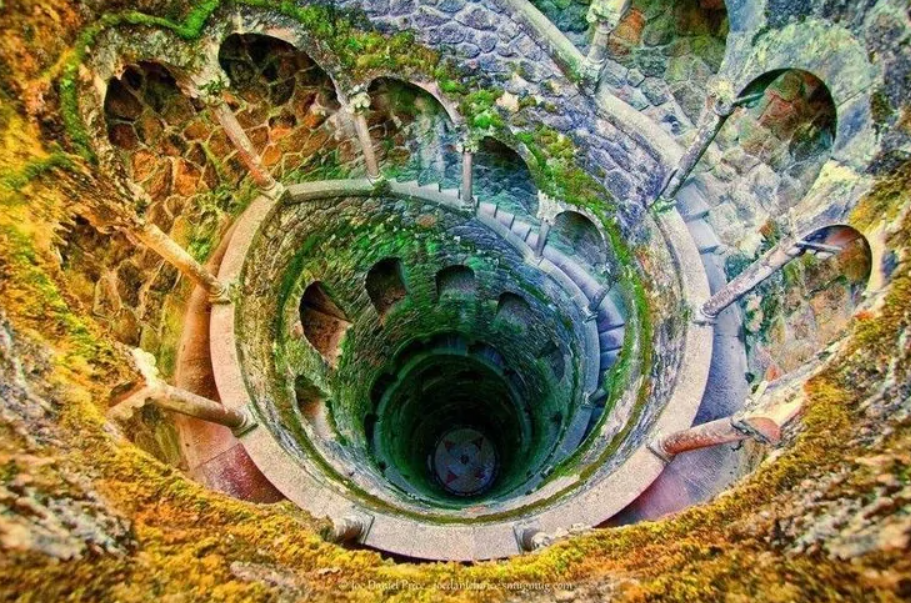 Kamenná špirála hlboko do zeme, pokrytá zeleným machom.