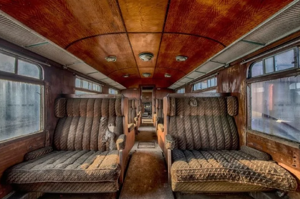 Interiér starého železničného vozňa s retro sedadlami z dreva a látky, zachytený v jedinečnej atmosfére.