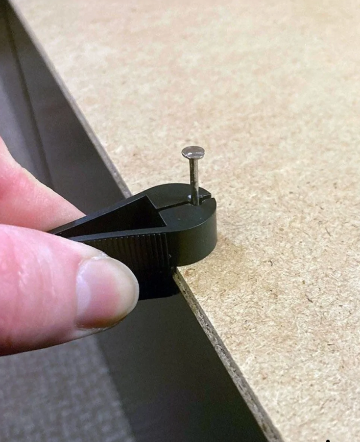 Nástroj na presné zatĺkanie klincov do drevenej dosky, detailný pohľad.