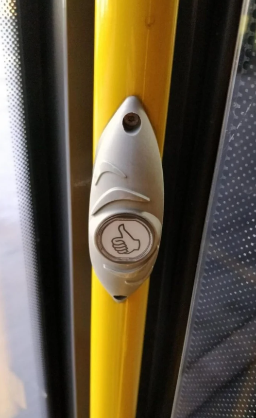 Tlačidlo na žltom stĺpe v autobuse na zastavenie.