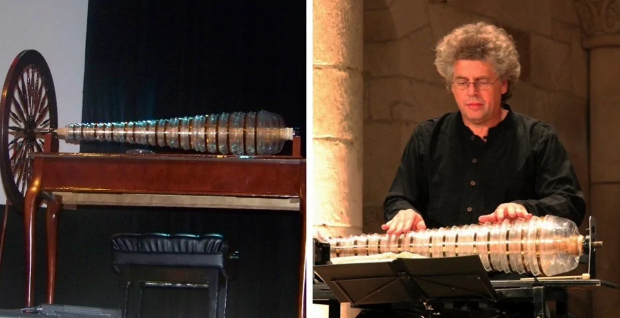 Sklenená harmonika na pódiu a hudobník hrajúci na ňu počas koncertu.