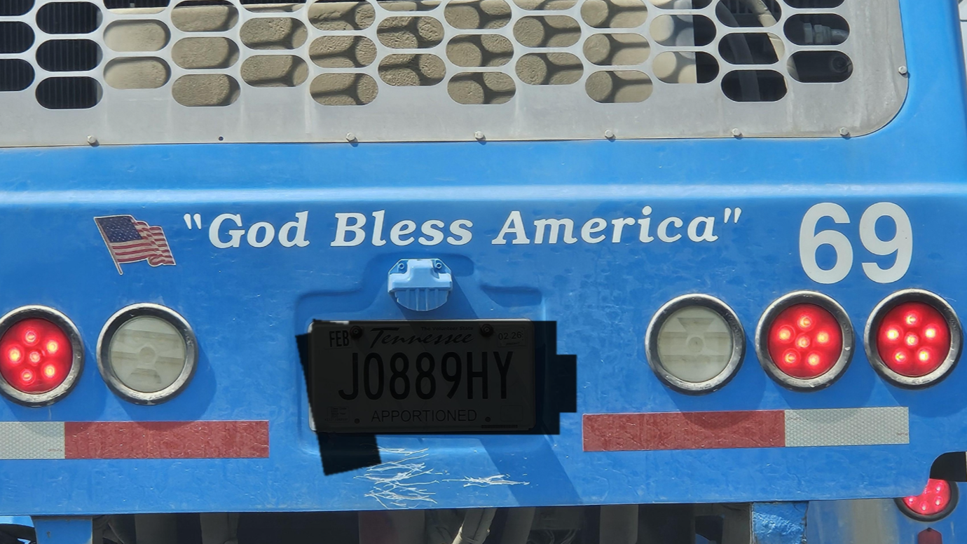 Nákladné auto s nápisom God Bless America, americkou vlajkou a číslicou 69 na zadnej strane.