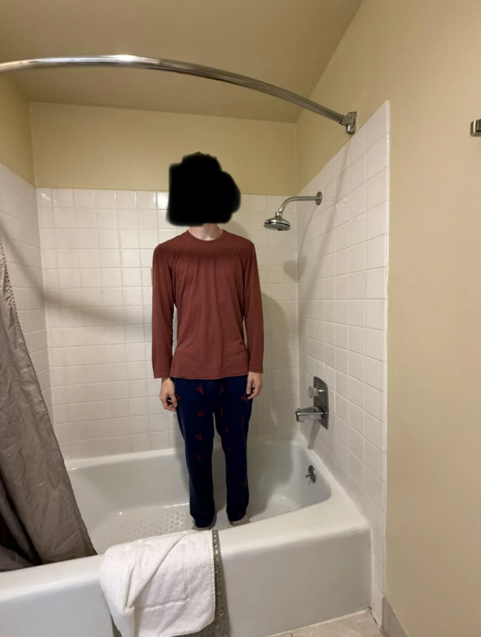 Osoba stojaca vo vani s hlavou rozmazanou kvôli ochrane súkromia.