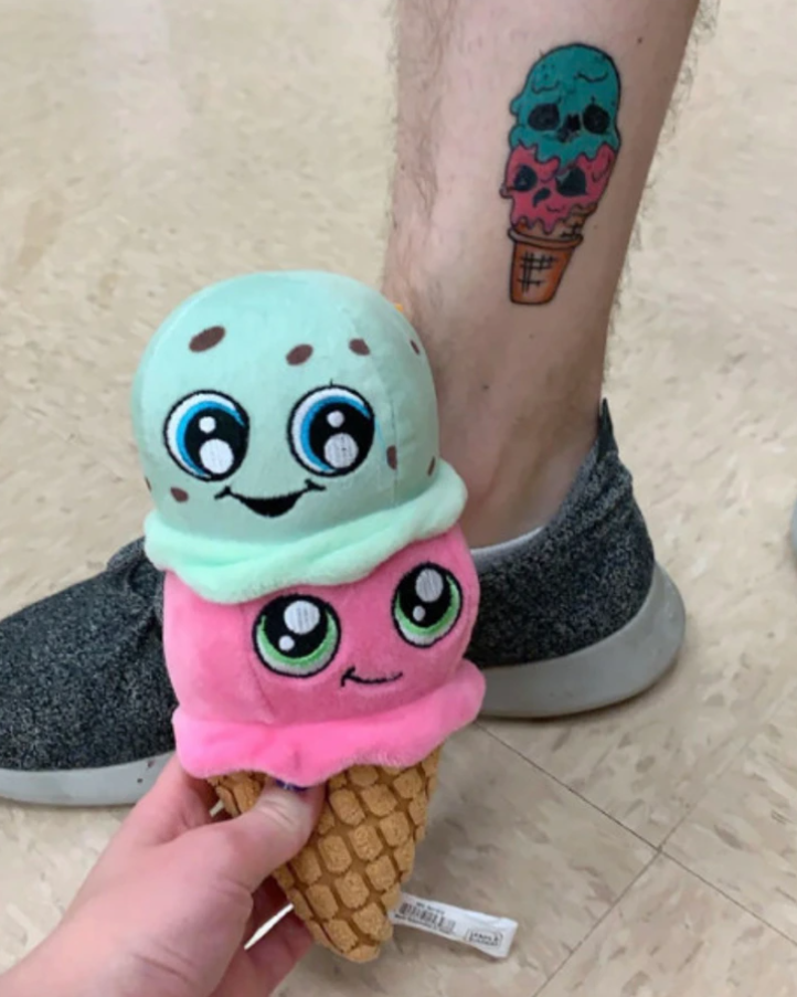 Mäkká hračka zmrzliny s tvárami a rovnaké tetovanie na nohe.