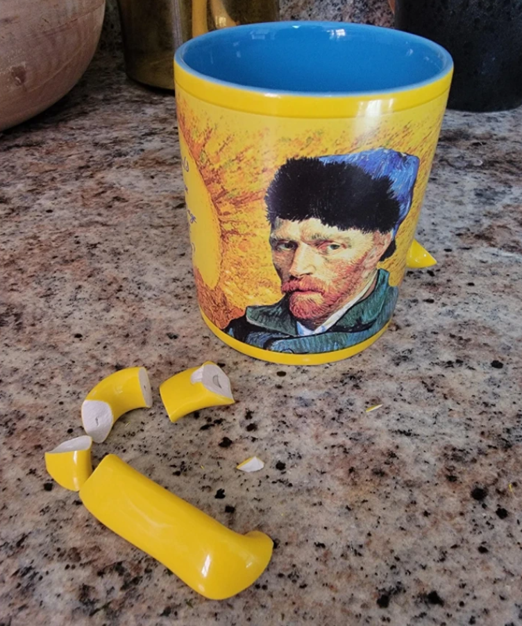 Rozbitý žltý hrnček s motívom slávneho maliara na kuchynskej pracovnej doske.