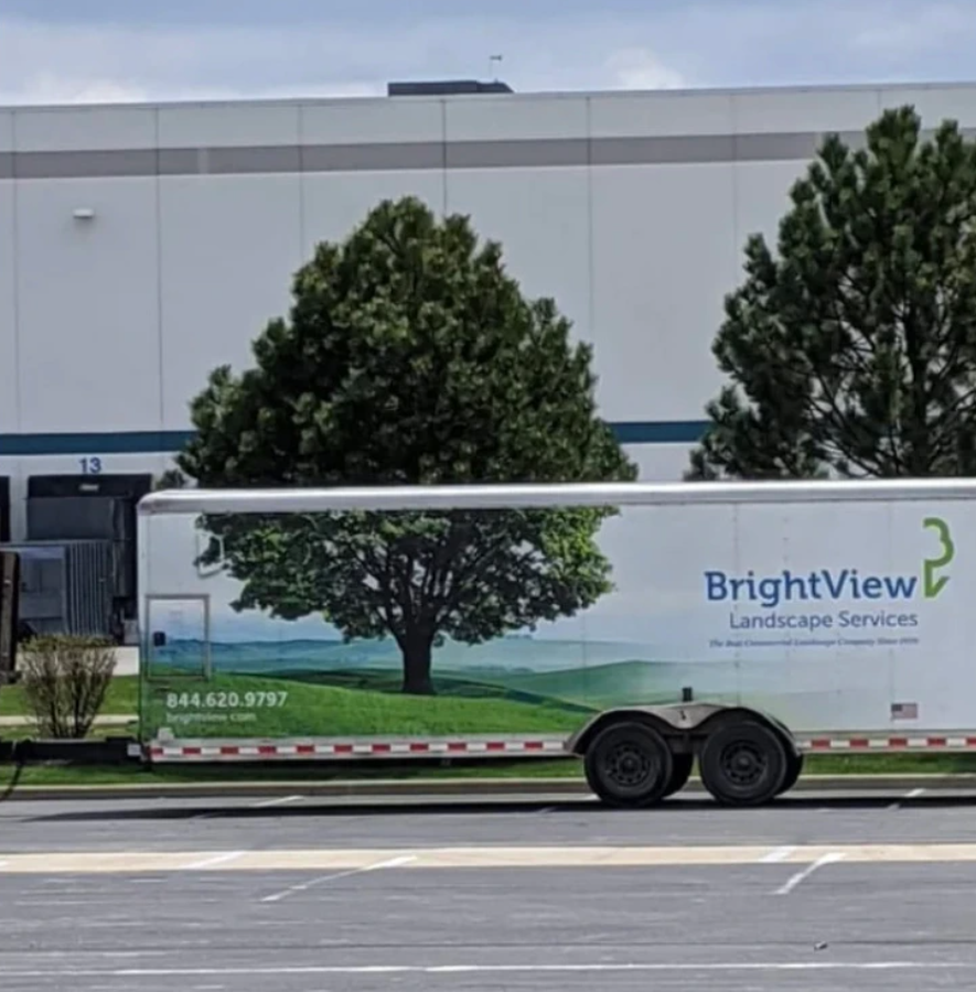 Nákladné auto BrightView s potlačou stromu pred budovou, reklama na záhradnícke služby.