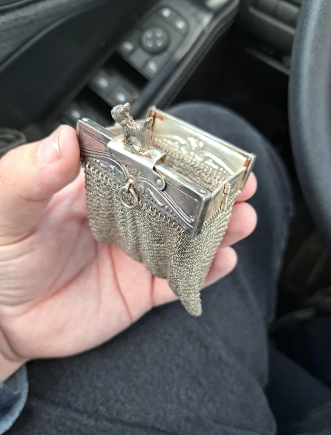 Malá retiazková taštička s dekoratívnym uzáverom v ruke, ideálna na elegantné doplnky.