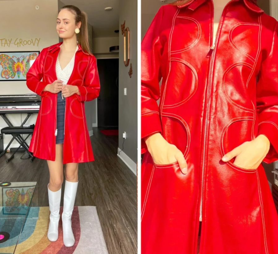 Žena v červenom koženom kabáte, biele čižmy, stojí v obývačke so stenami zdobenými umením. Skúmanie detailu kabátu.