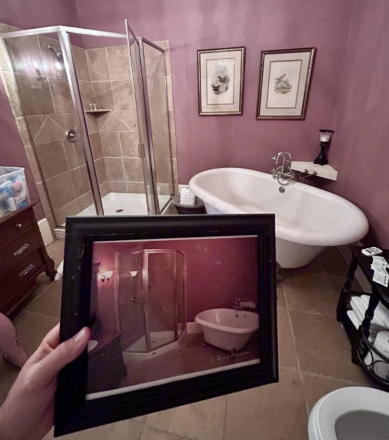 Fotografia fialovej kúpeľne s vaňou a sprchou, zobrazená na stene i v ráme na zemi.