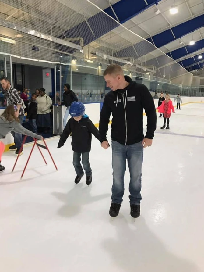 Otec a syn sa spolu korčuľujú na ľadovej ploche, učia sa a užívajú si zábavu na klzisku.