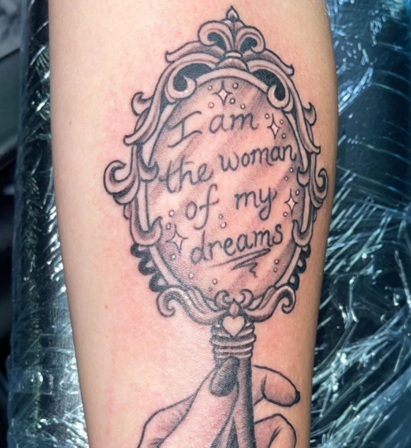 Tetovanie na ruke s nápisom I am the woman of my dreams v ozdobnom ráme.