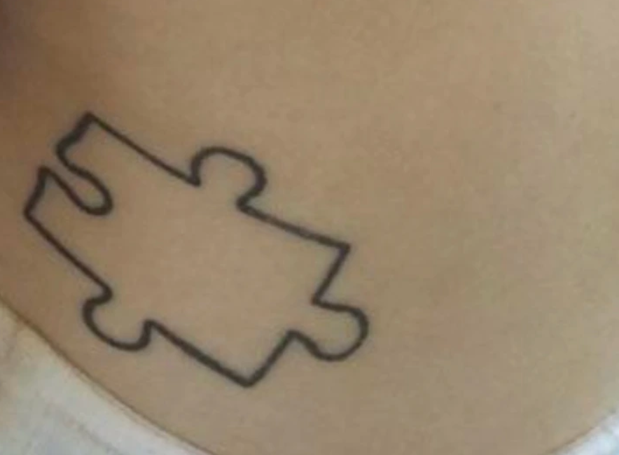 Tetovanie puzzle dielika na pokožke, minimalistický čierny obrys.