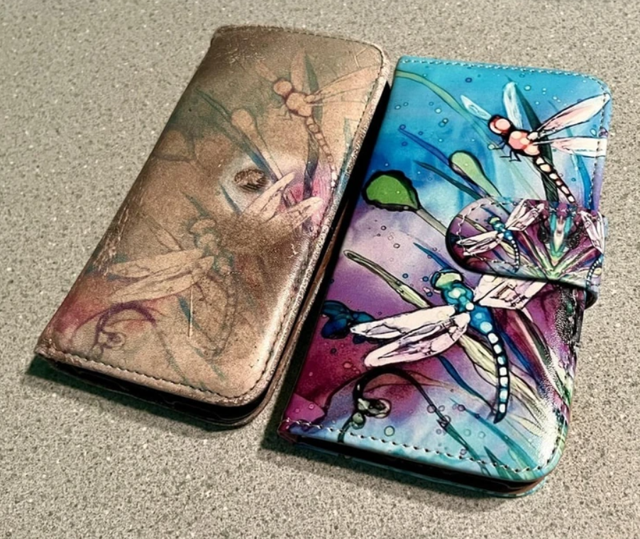 Dva zdobené obaly na telefón s farebnými motívmi vážok na kamennom povrchu.