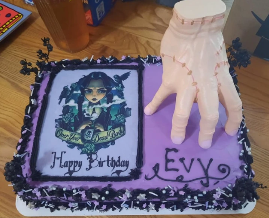 Netradičná narodeninová torta s gotickým motívom a 3D rukou na fialovom pozadí s nápisom „Evy“.