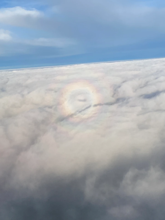 Dúha nad oblakmi počas letu, jasná obloha nad mrakmi, pôsobivý výhľad z lietadla.
