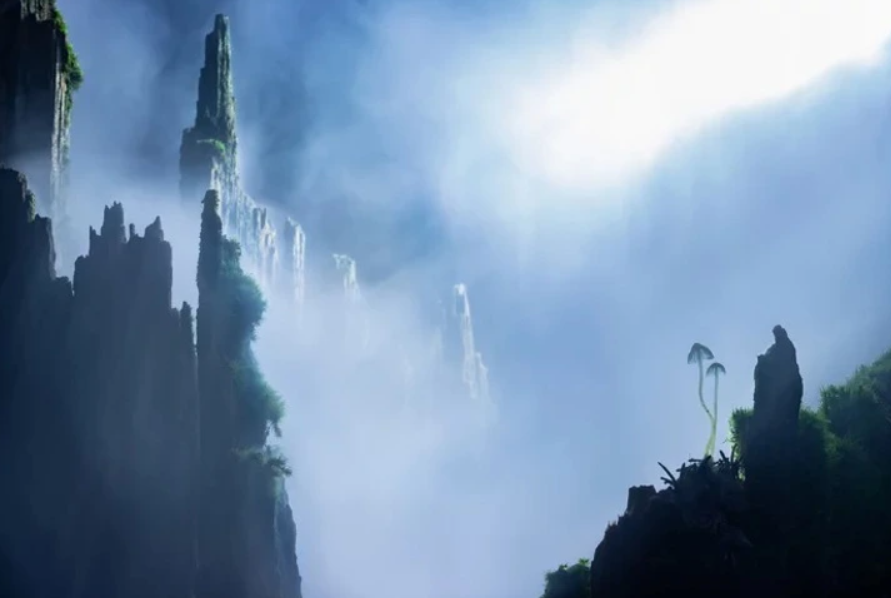Hmlistá krajina s vysokými skalnými útesmi a jemným svetlom dopadajúcim zhora, vytvára mystickú atmosféru.
