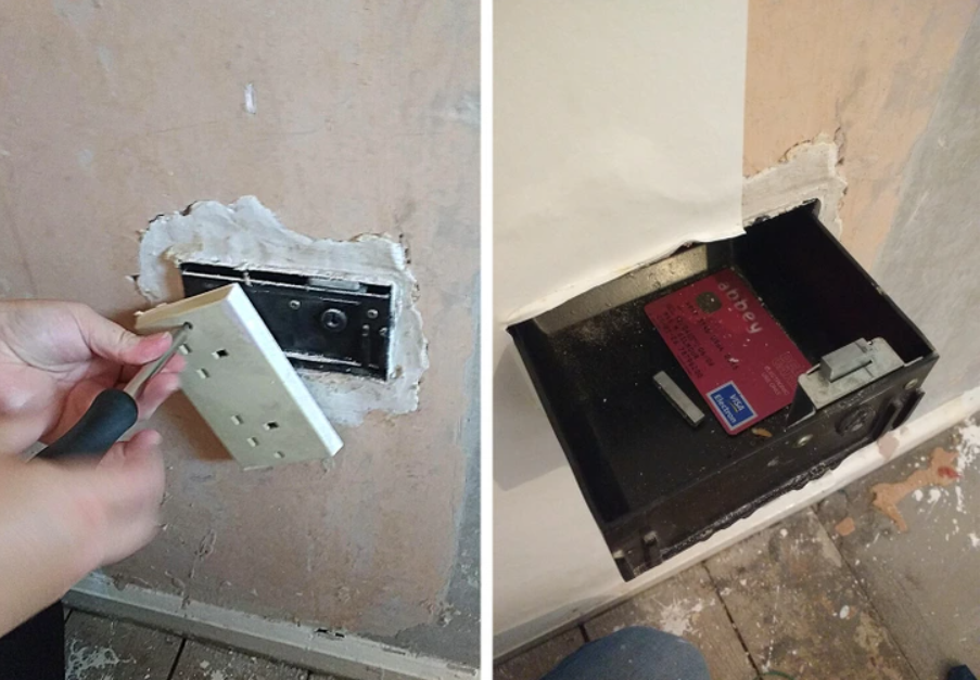 Osoba otvára tajný skrývaný trezor za falošnou zásuvkou v stene.