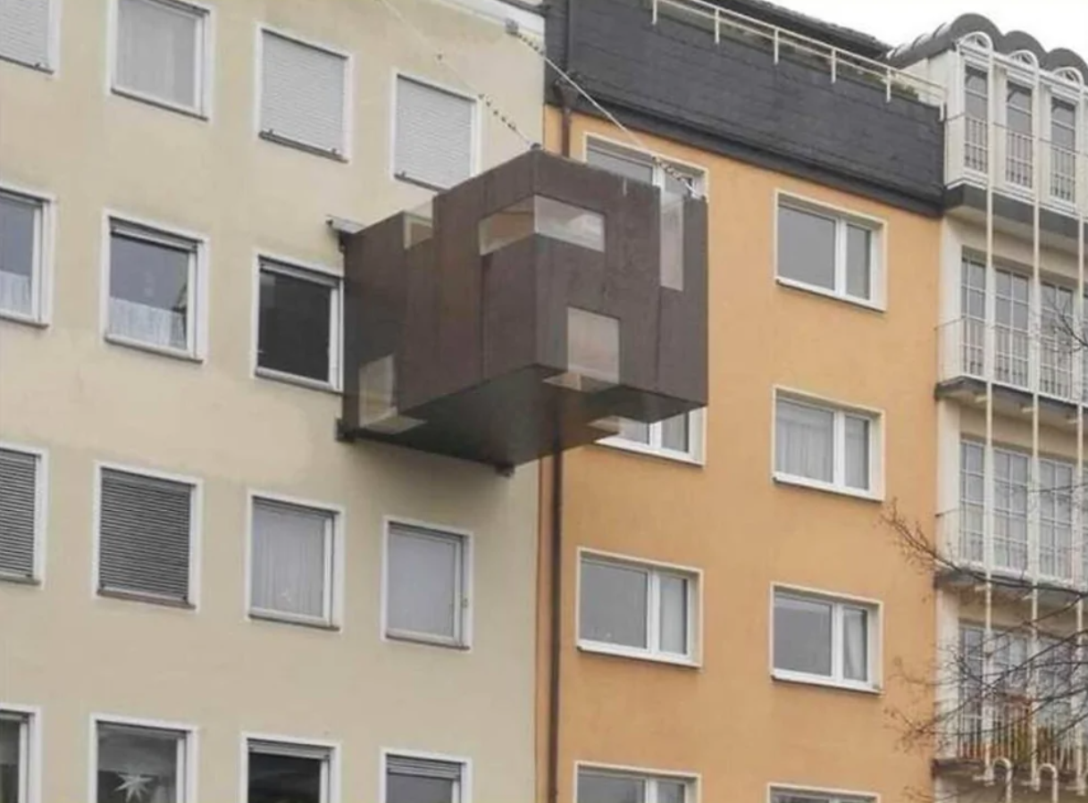 Moderný vysunutý balkón v tvare kubusu na mestskom bytovom dome.