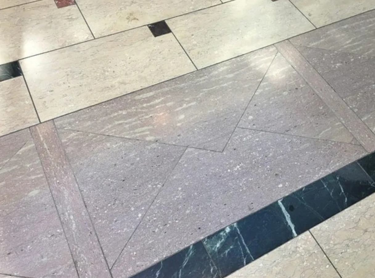 Kachličková podlaha s dizajnom obálky vytvoreným rozdielnymi odtieňmi a textúrou dlaždíc.