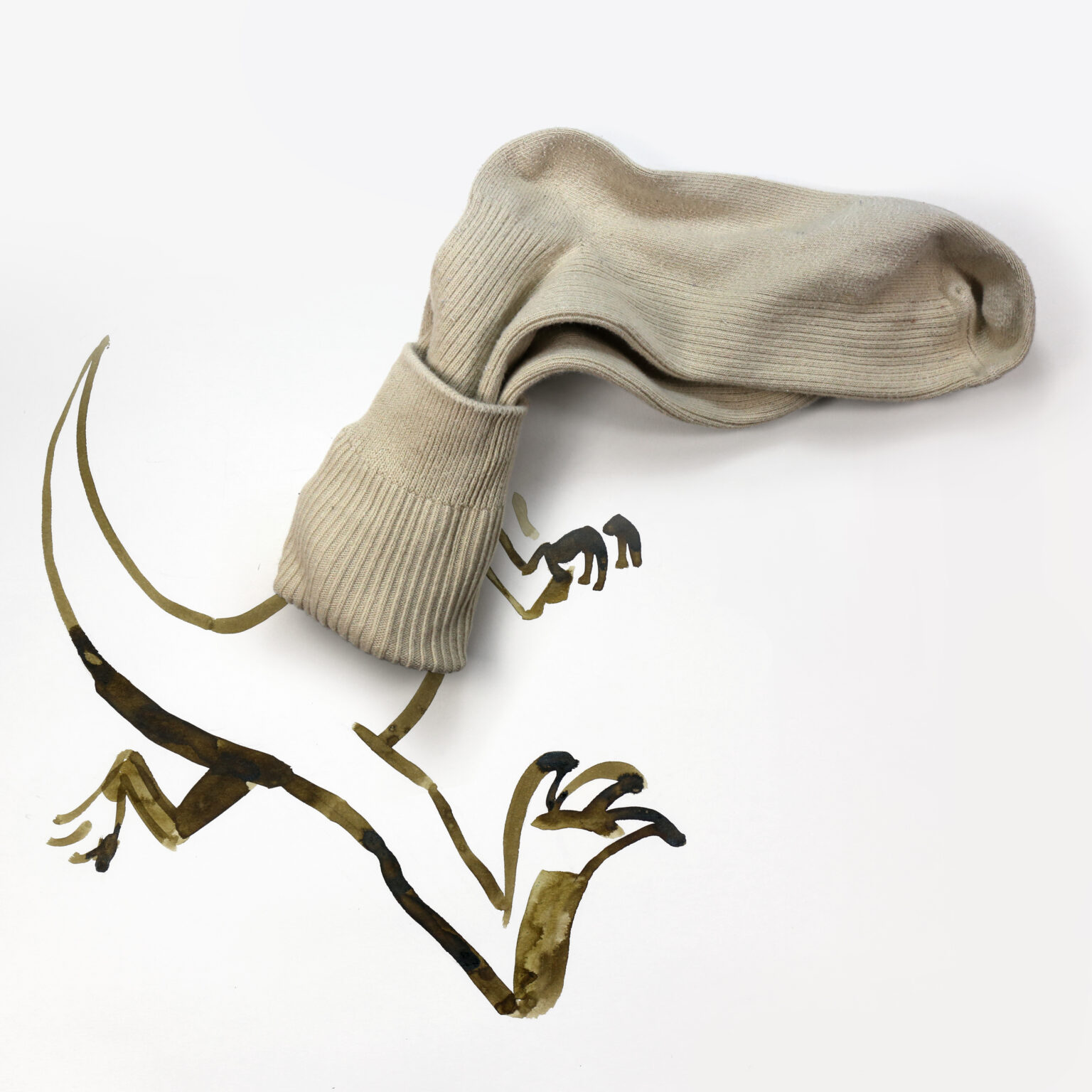 Béžová ponožka vytvára ilúziu dinosaura s namaľovaným telom na bielom pozadí. Kreatívny umelecký koncept.