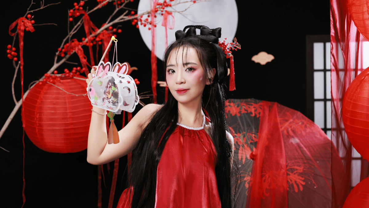 Žena v tradičnom červenom odeve s lucernou na oslavách čínskeho Nového roka.