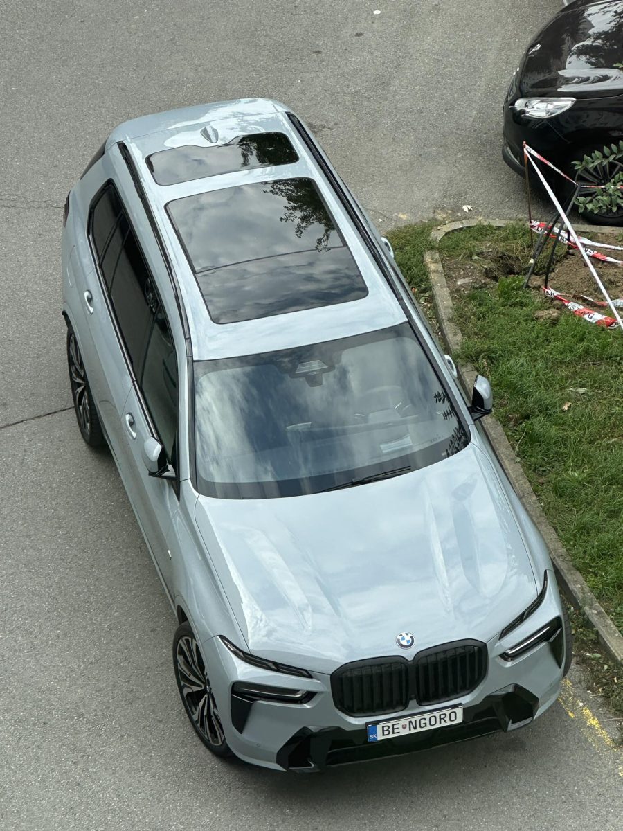 SUV so sklenenou strechou na ulici, pohľad zhora. Moderný dizajn auta, parkovanie vedľa obrubníka.