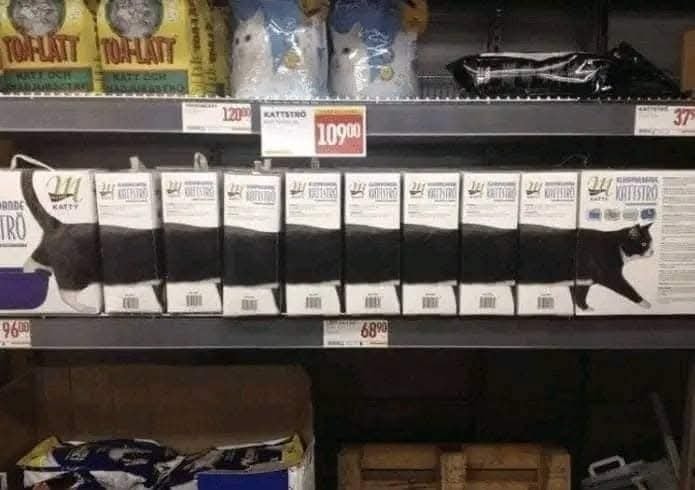 Krabice pre mačky na regáli tvoria obrázok čiernej a bielej mačky, ktorá sa tiahne cez všetky obaly.