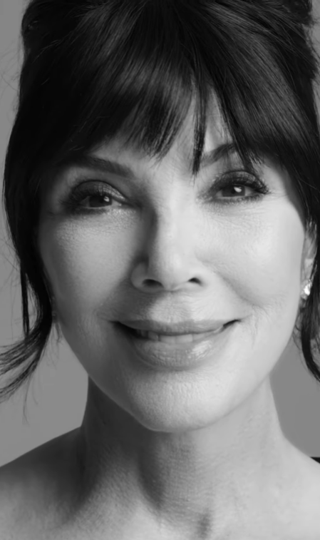 Ženský portrét v čiernobielej farbe s úsmevom a tmavými vlasmi upravenými do drdolu.