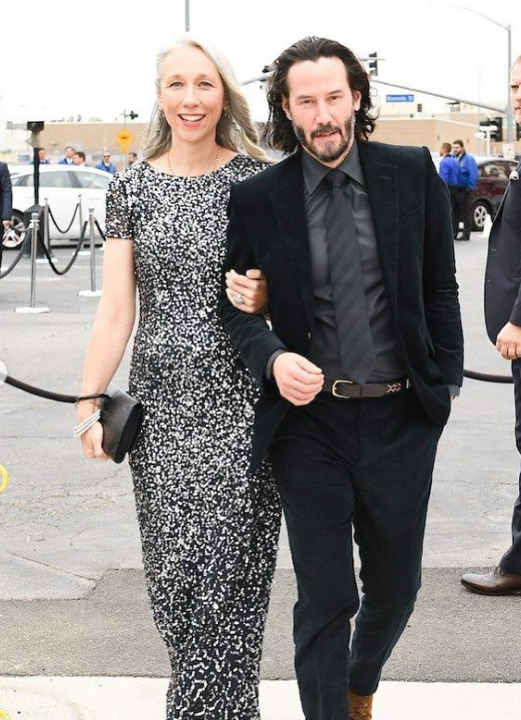 Prominentný pár prichádza na červený koberec v štýlovom večernom oblečení.