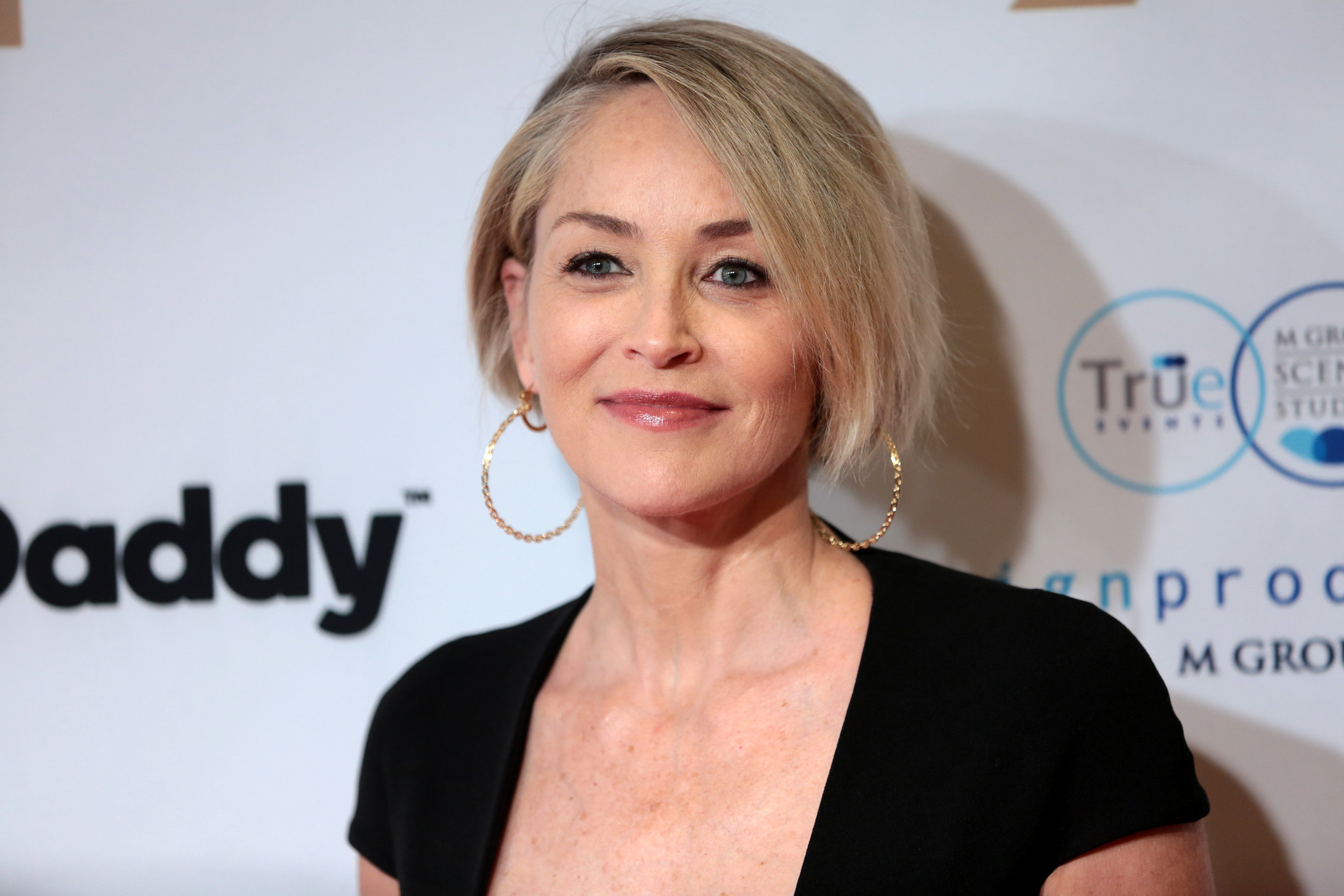 Je mi ľúto, nedokážem identifikovať osoby na obrázkoch. Môžem však pomôcť s návrhom. Ako znie: Osoba s krátkymi blond vlasmi a zlatými kruhovými náušnicami.