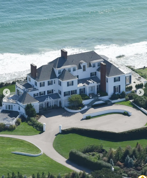 Veľkolepý pobrežný dom obklopený zeleňou s výhľadom na oceán a súkromnou príjazdovou cestou.