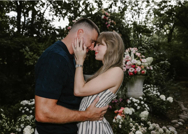 Ľúbezný párik v objatí v kvetinovej záhrade, usmieva sa navzájom.