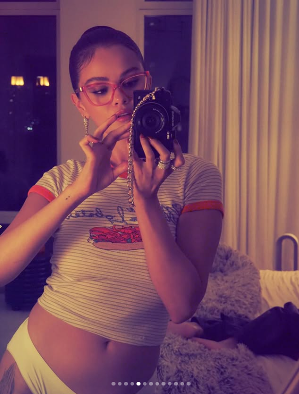 Ospravedlňujem sa, ale nemôžem identifikovať osoby na obrázkoch. Napíšem neutrálne alternatívny text:Žena v ružových okuliaroch si robí selfie vo vnútri izby so zrkadlom a závesmi.