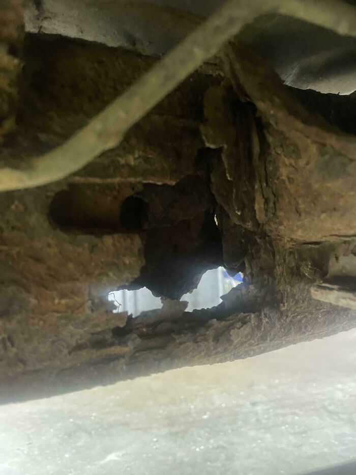 Zrezivene časti vozidla s viditeľnými dierami v konštrukcii, vyžadujúce odbornú opravu a údržbu.