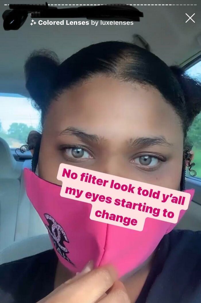 Osoba v aute nosí ružové rúško a ukazuje farebné kontaktné šošovky, ktoré menia farbu očí.