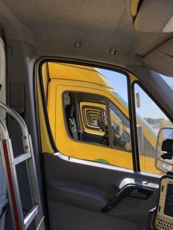 Rady žltých dodávok s otvorenými dverami v perspektíve, pohľad z interiéru jednej z nich.