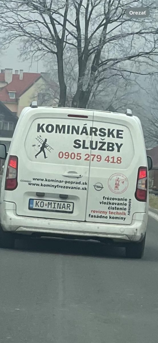 Dodávka kominárskych služieb s kontaktmi na zadnej strane na ceste, holé stromy na pozadí.