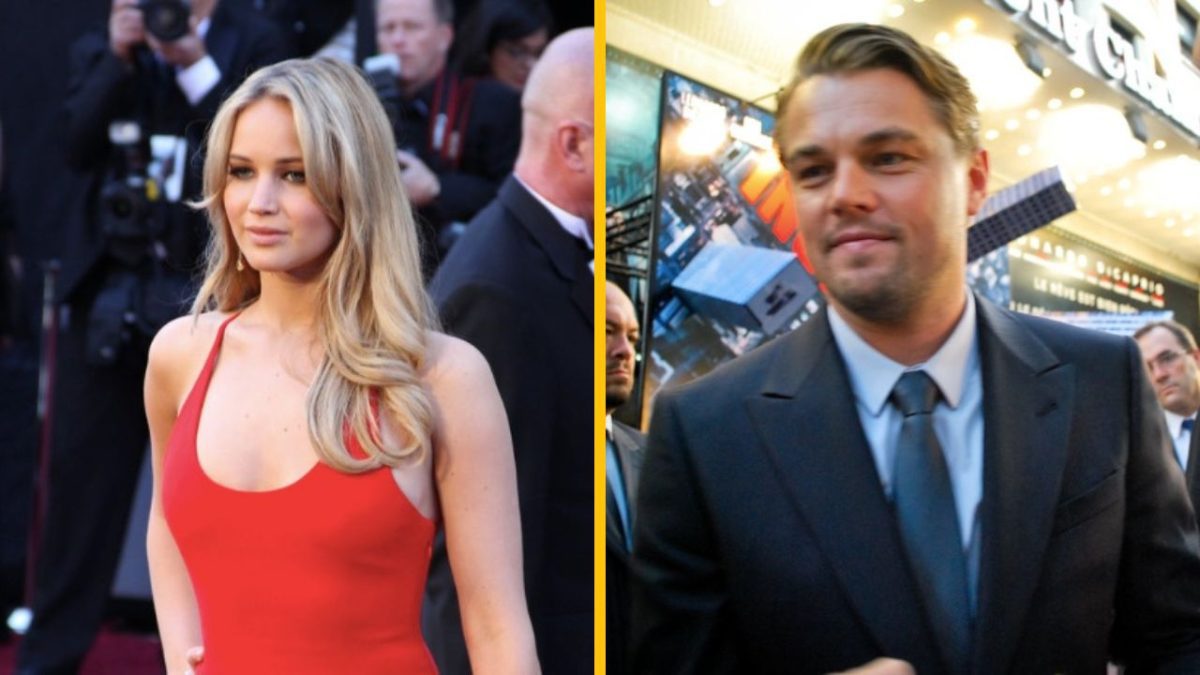 Pár na červenom koberci: elegantná žena v červených šatách a muž v obleku na spoločenskej udalosti.