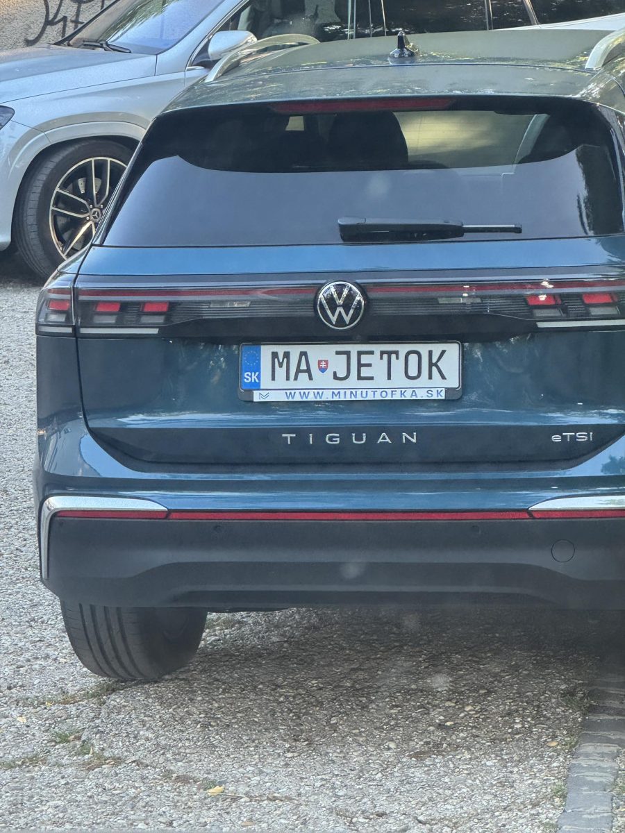 Modré SUV Volkswagen Tiguan s poznávacou značkou „MAJETOK“ na parkovisku.