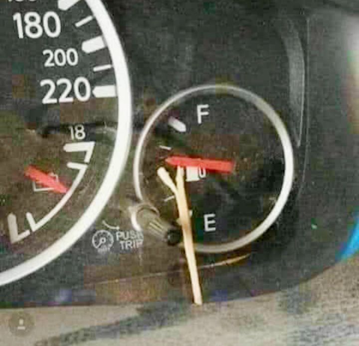 Tachometer auta so zápalkou komicky držiacou ručičku ukazovateľa paliva na maximálnej hodnote.